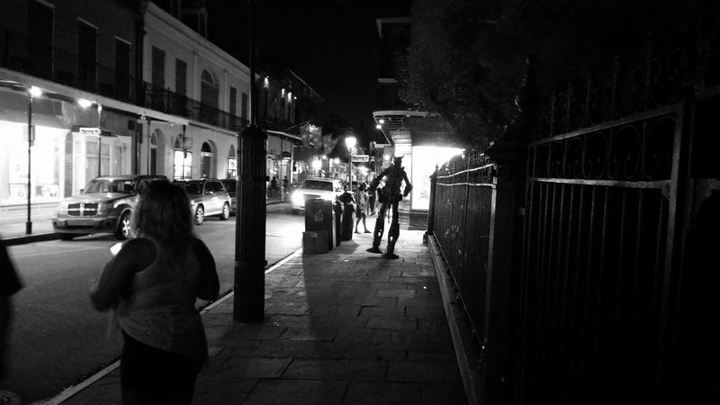 Street performer walking on street at night, Royal Street, New Orleans