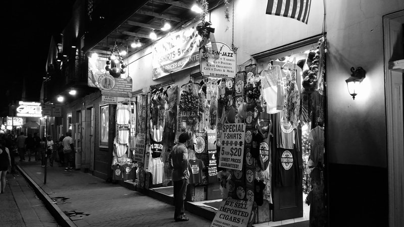 Man standing outside of souvenir store at night, French Quarter, New Orleans